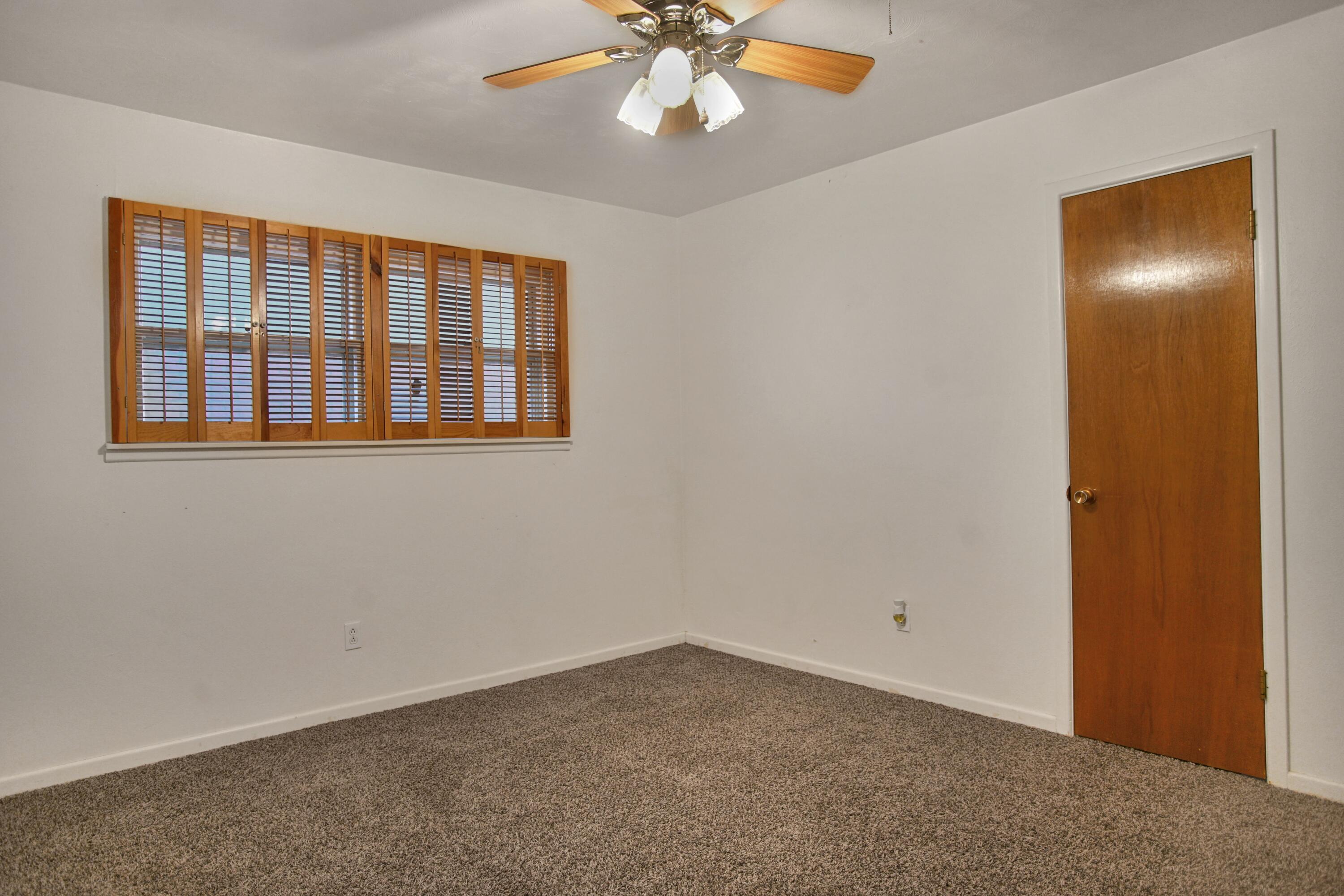 5420 8th Street Lubbock, TX 79416 - Photo 25 of 35 an empty room with a chandelier fan and windows