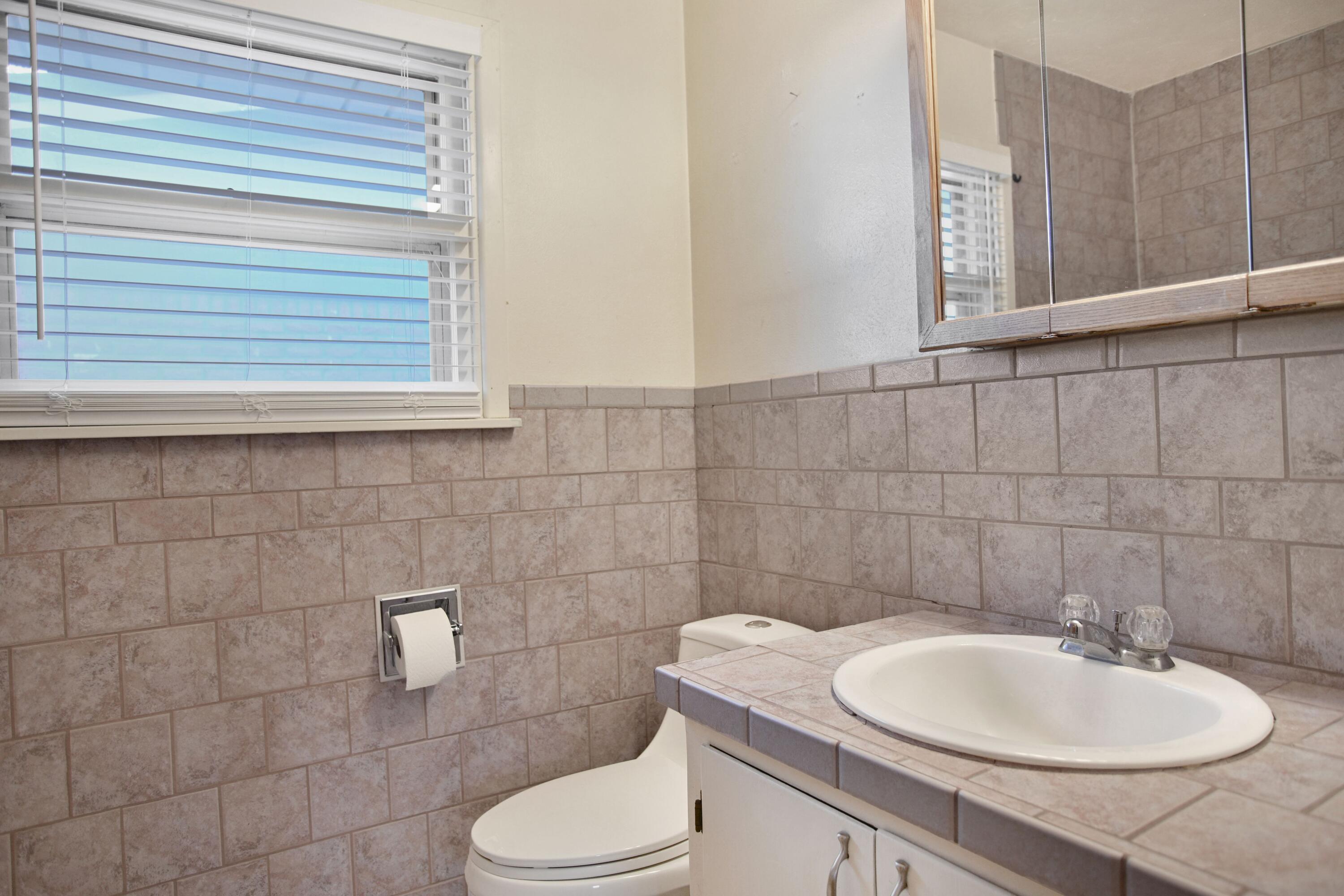 5420 8th Street Lubbock, TX 79416 - Photo 29 of 35 a bathroom with a toilet sink and mirror