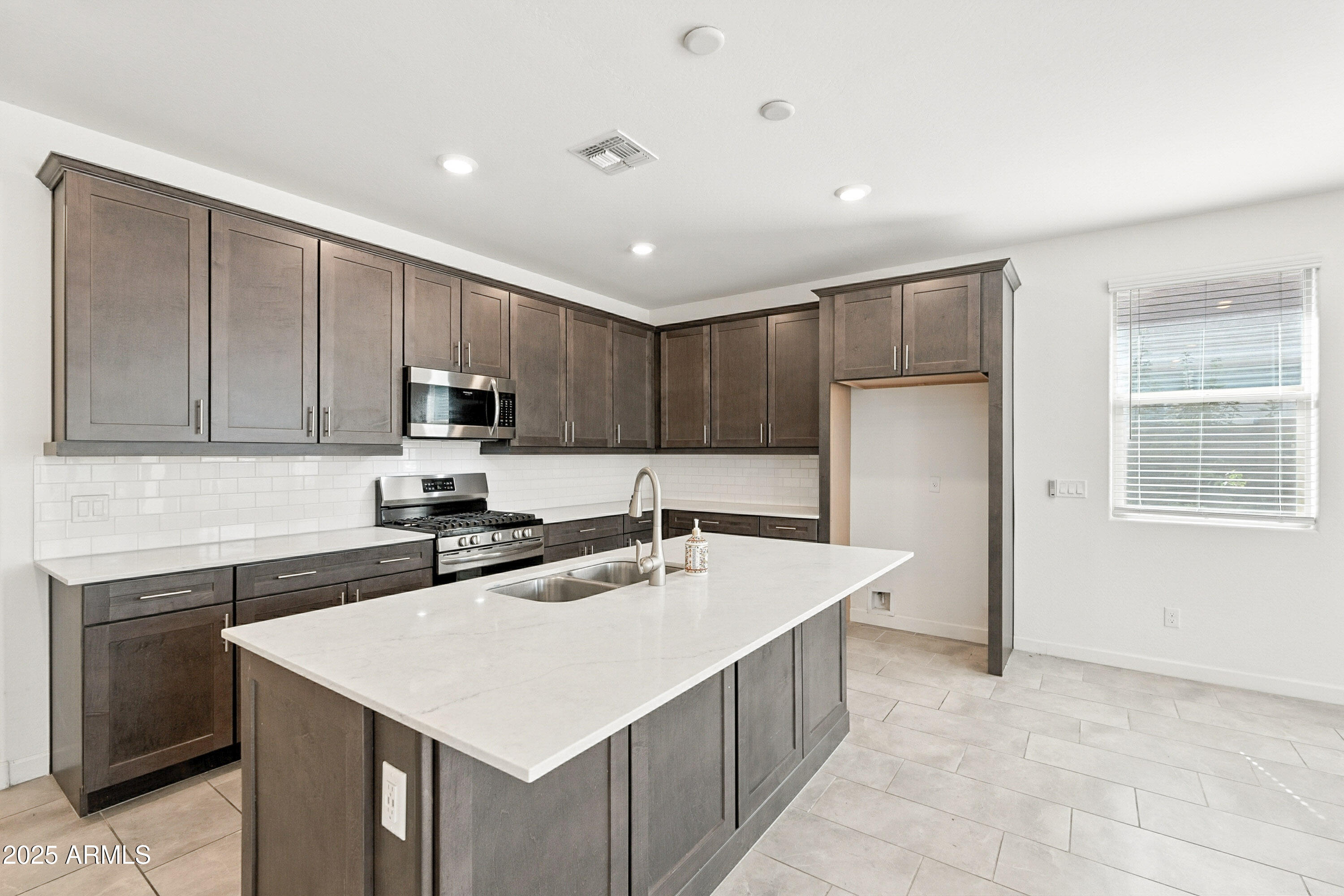 2816 West Pollack Street Phoenix, AZ 85041 - Photo 55 of 63 a kitchen with stainless steel appliances a sink a stove a refrigerator a center island and a window