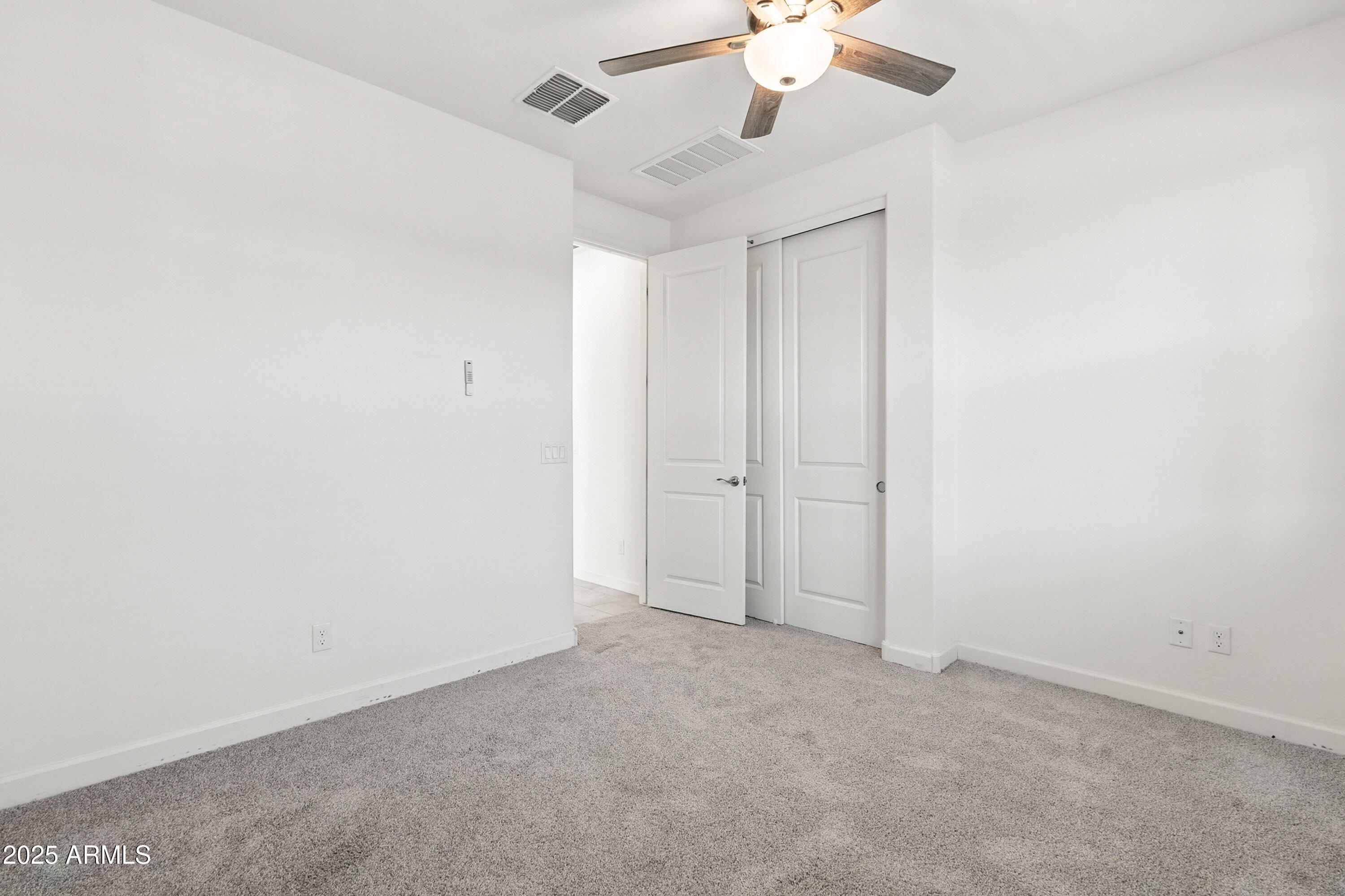 2816 West Pollack Street Phoenix, AZ 85041 - Photo 62 of 63 an empty room with a chandelier fan and a ceiling fan