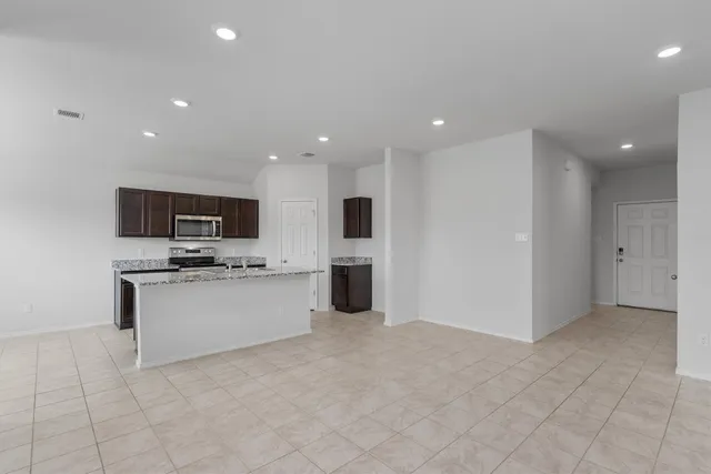 a large kitchen with stainless steel appliances a stove a sink and a microwave