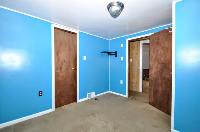 an empty room with closet and a bathroom