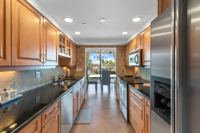 a kitchen with kitchen island granite countertop a stove a sink and a refrigerator