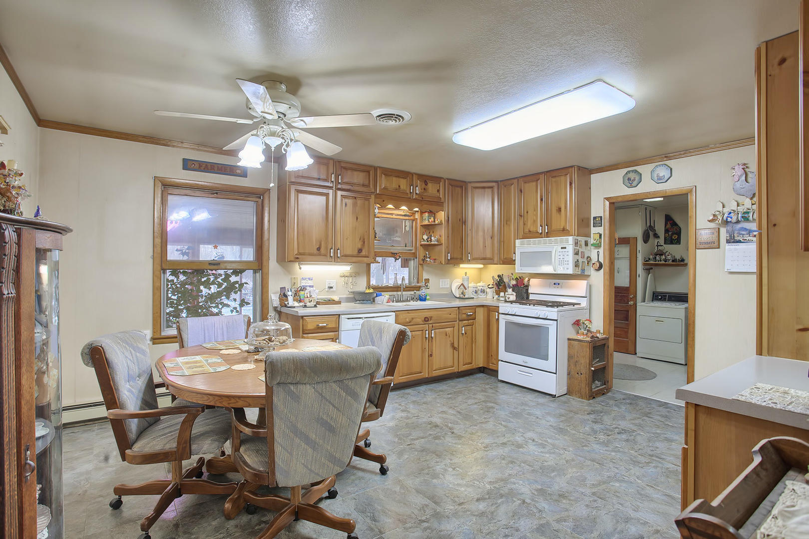 408 Kyle Street Ogden, IL 61859 - Photo 5 of 24 a kitchen with cabinets a refrigerator and chairs