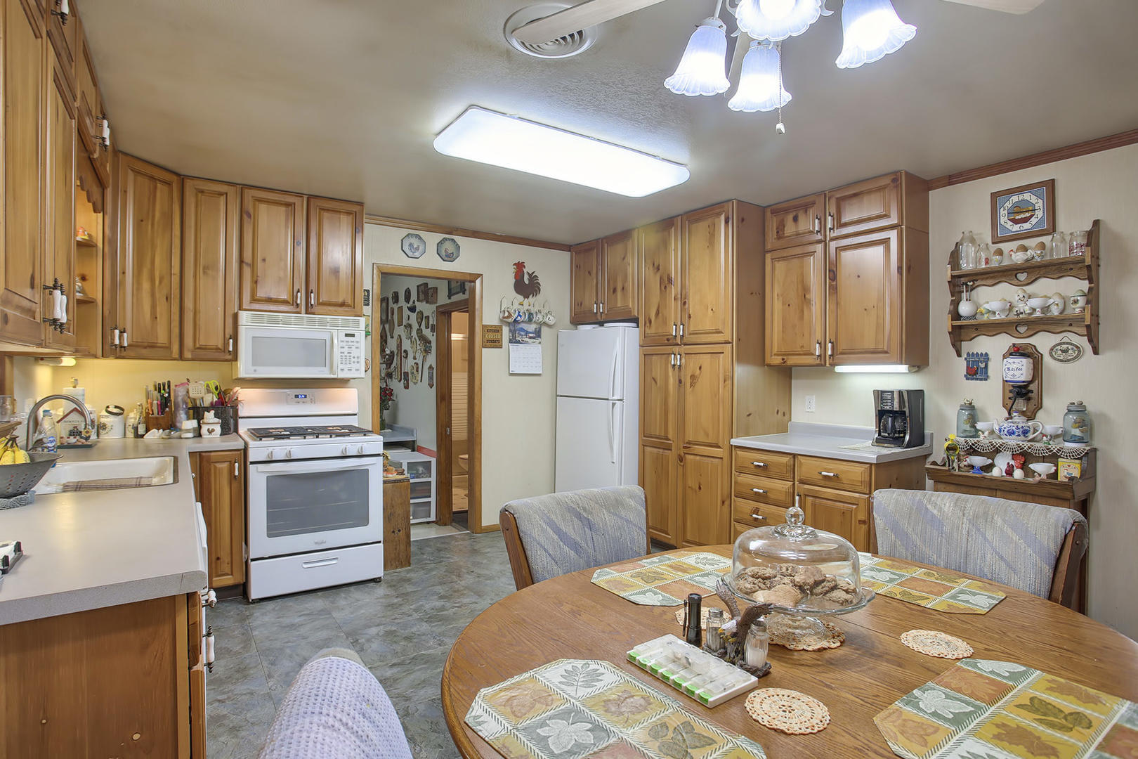 408 Kyle Street Ogden, IL 61859 - Photo 7 of 24 a kitchen with stainless steel appliances kitchen island granite countertop a refrigerator a stove a sink dishwasher and wooden dining table with wooden floor