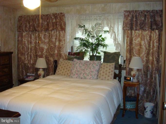 19515 Frederick Road, Unit 191 Germantown, MD 20876 - Photo 9 of 13 a large bed sitting in a bedroom next to a yard