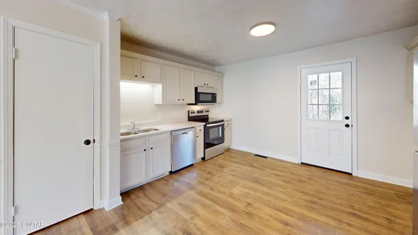 a kitchen with a sink and steel appliances