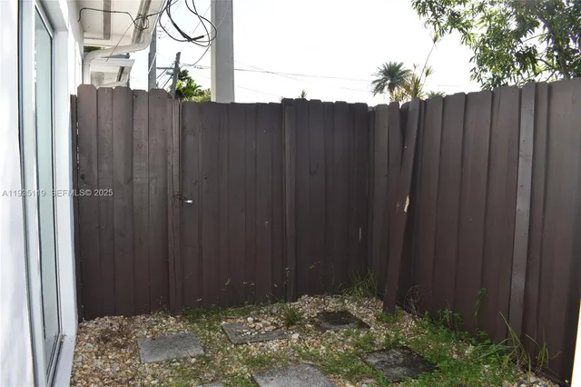 a view of backyard with wooden fence