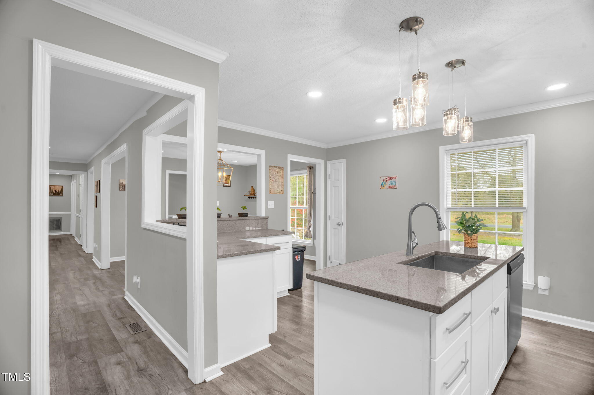 1022 Glover Road Dunn, NC 28334 - Photo 11 of 31 a kitchen with kitchen island granite countertop a stove and white cabinets with wooden floor