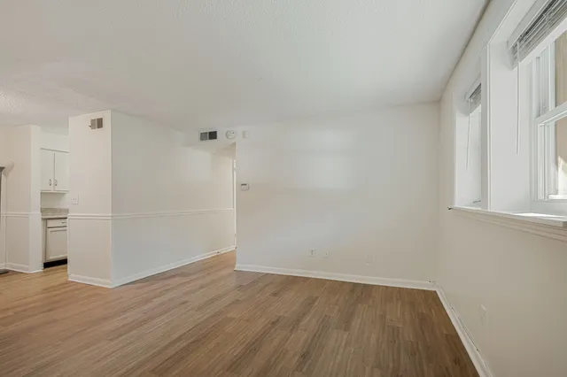 a view of a room with wooden floor and white walls
