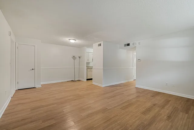 a view of an empty room with wooden floor