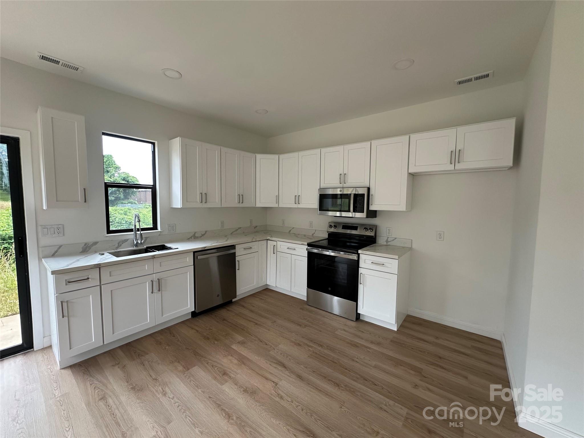 804 3rd St Place Southwest Hickory, NC 28602 - Photo 4 of 10 a kitchen with granite countertop white cabinets and white appliances