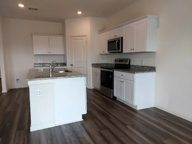 a kitchen with a sink stove and microwave