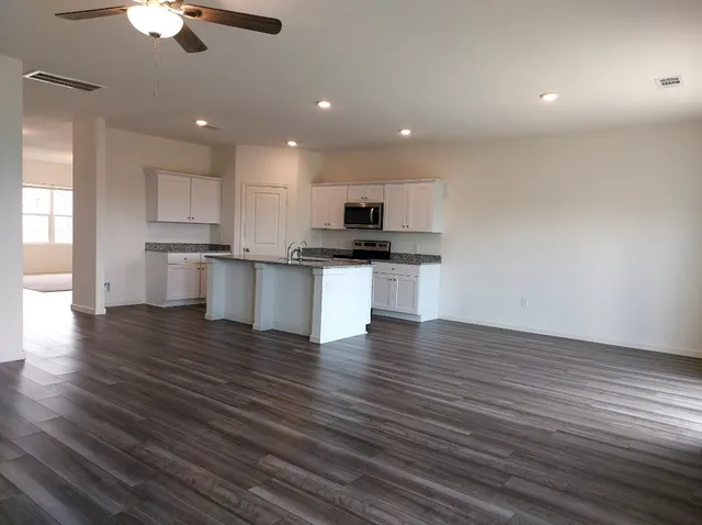 a kitchen with stainless steel appliances wooden floors and view living room