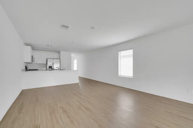 a view of a kitchen with wooden floor and window