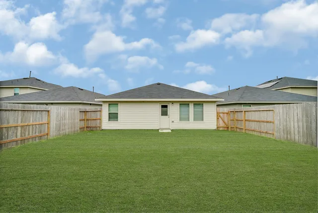 a view of a yard in front of a house with a large tree