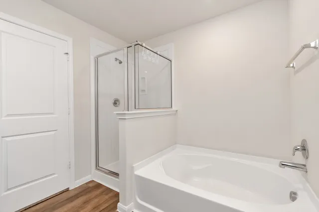 a white bath tub sitting next to a shower