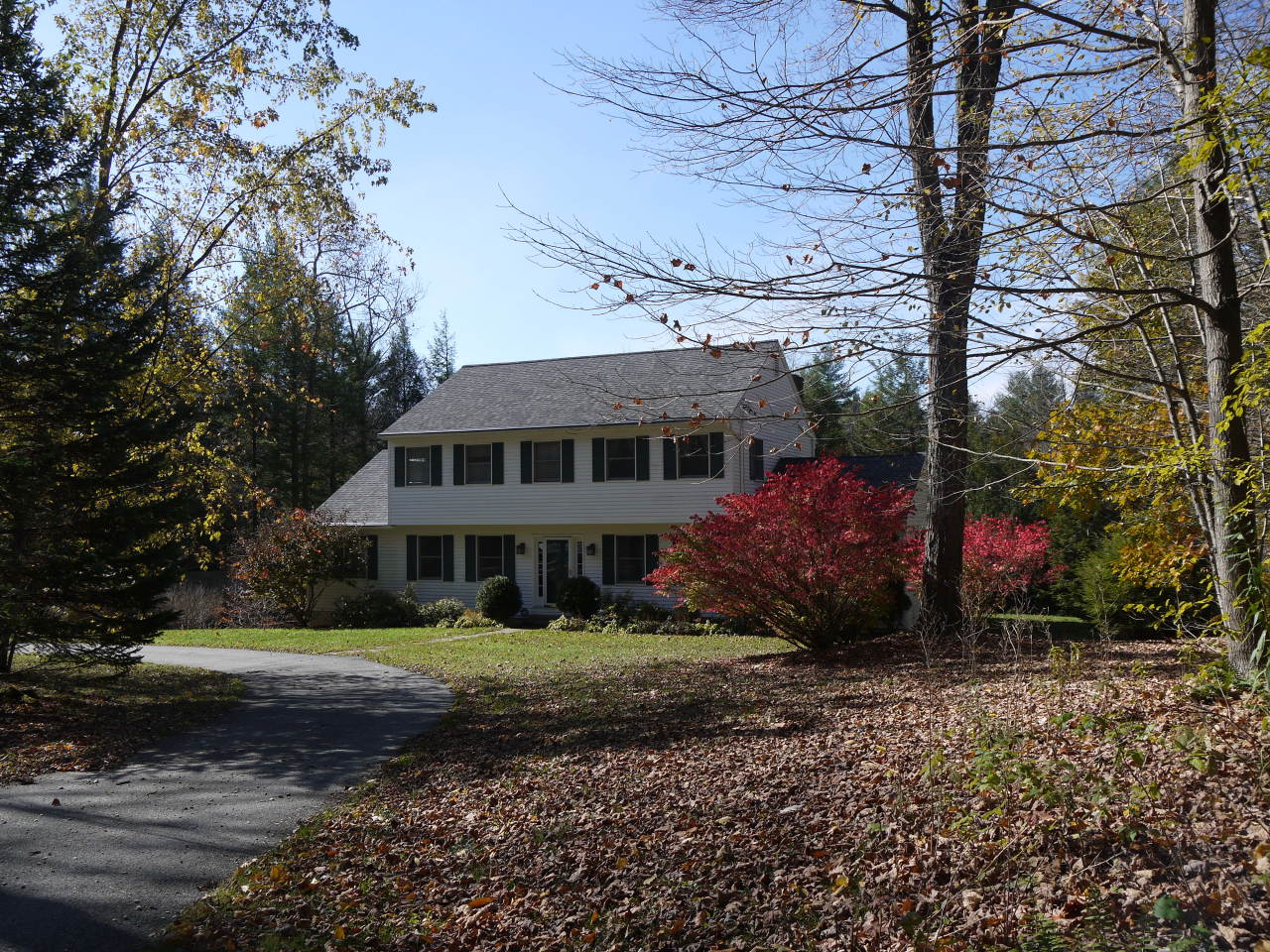 a front view of a house with a garden and trees