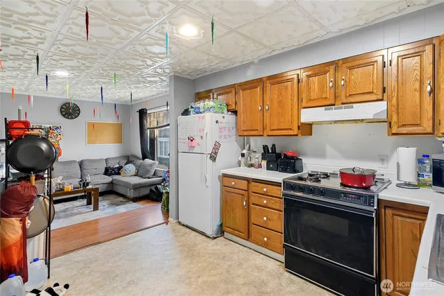a kitchen with stainless steel appliances a stove a sink cabinets and a window