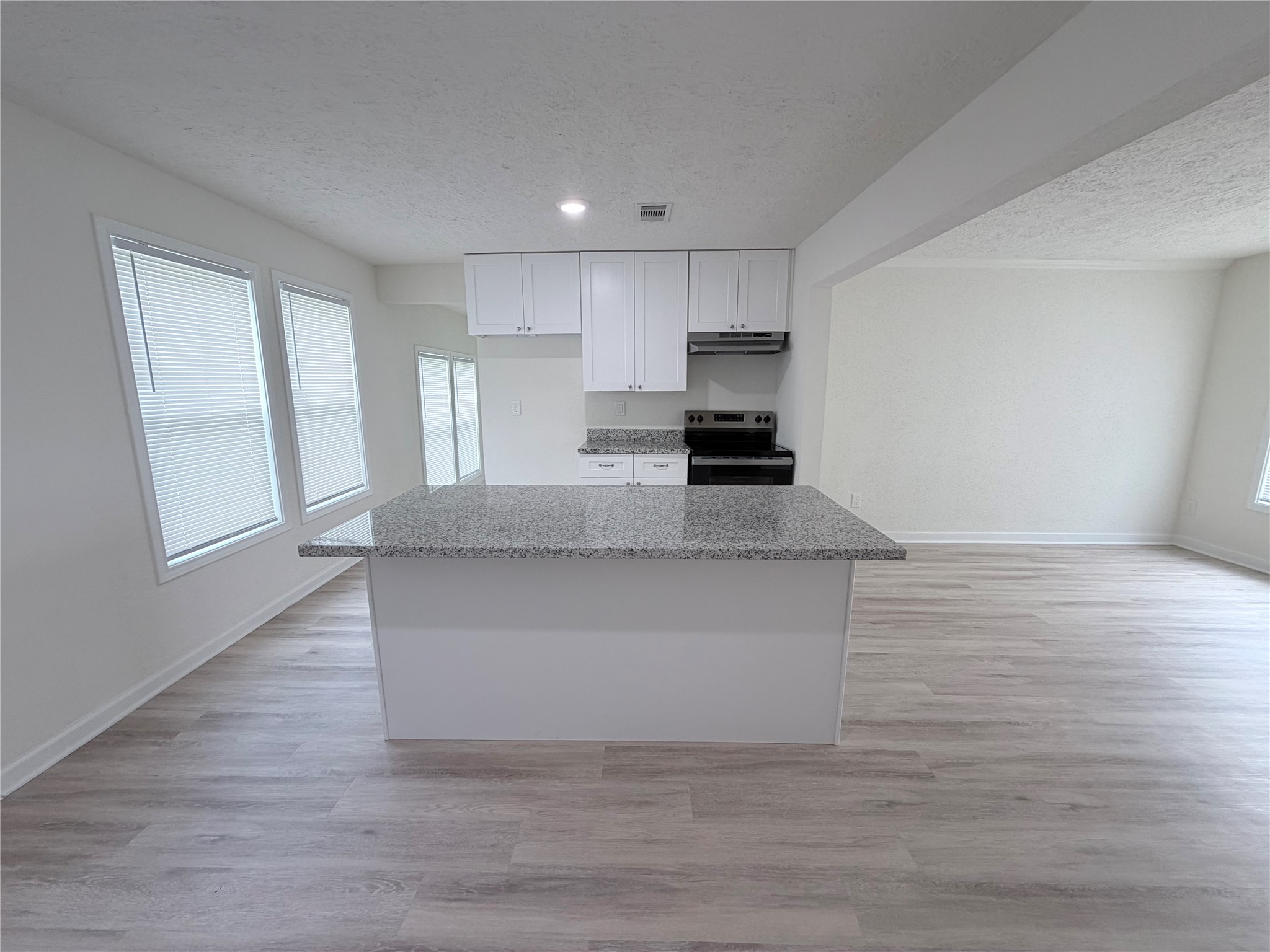 1112 3rd Street La Marque, TX 77568 - Photo 9 of 21 a large white kitchen with kitchen island a sink wooden floor and a stove