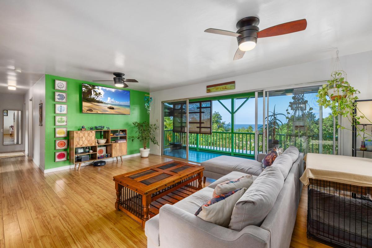 83-5434 Middle Keei Road Captain Cook, HI 96704 - Photo 2 of 30 a living room with furniture a floor to ceiling window and wooden floor