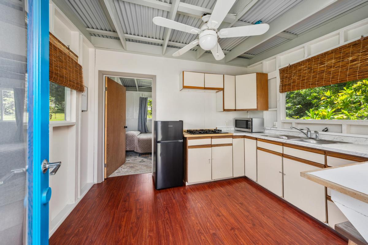 83-5434 Middle Keei Road Captain Cook, HI 96704 - Photo 22 of 30 a kitchen with a sink wooden floor and stainless steel appliances