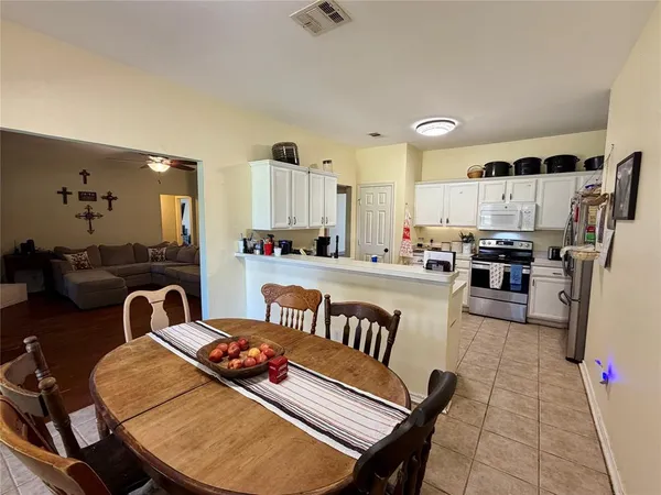 a kitchen with sink refrigerator dining table and chairs
