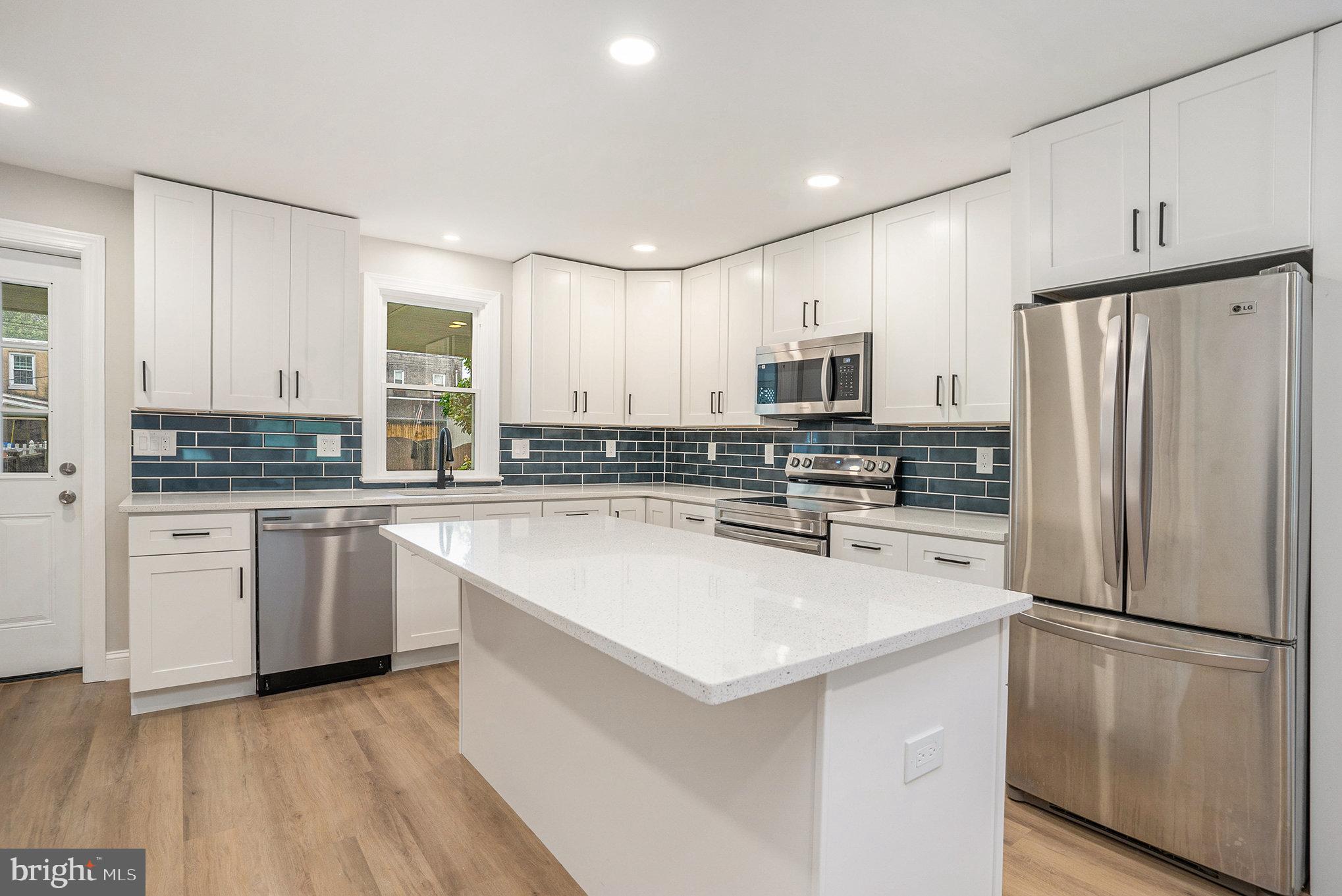 429 East 12th Avenue Conshohocken, PA 19428 - Photo 8 of 34 a kitchen with a refrigerator a stove top oven a sink and cabinets