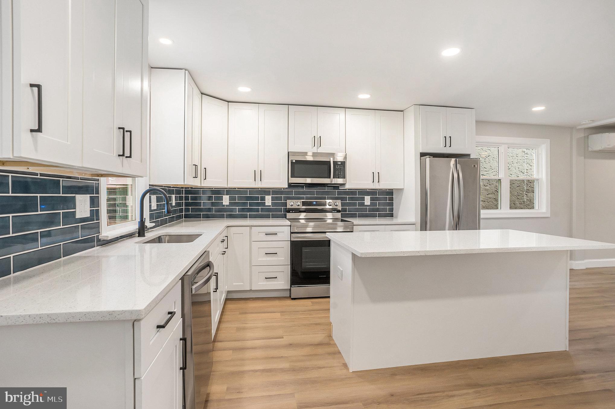 429 East 12th Avenue Conshohocken, PA 19428 - Photo 9 of 34 a kitchen with stainless steel appliances kitchen island granite countertop a stove a sink and a refrigerator