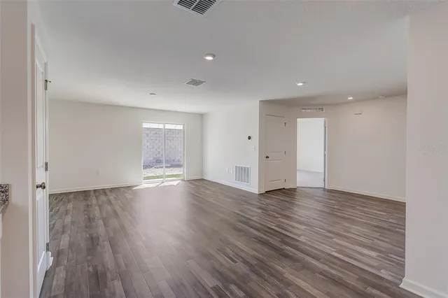 an empty room with wooden floor and window