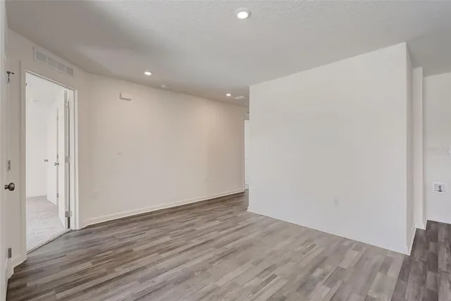 a view of an empty room with wooden floor