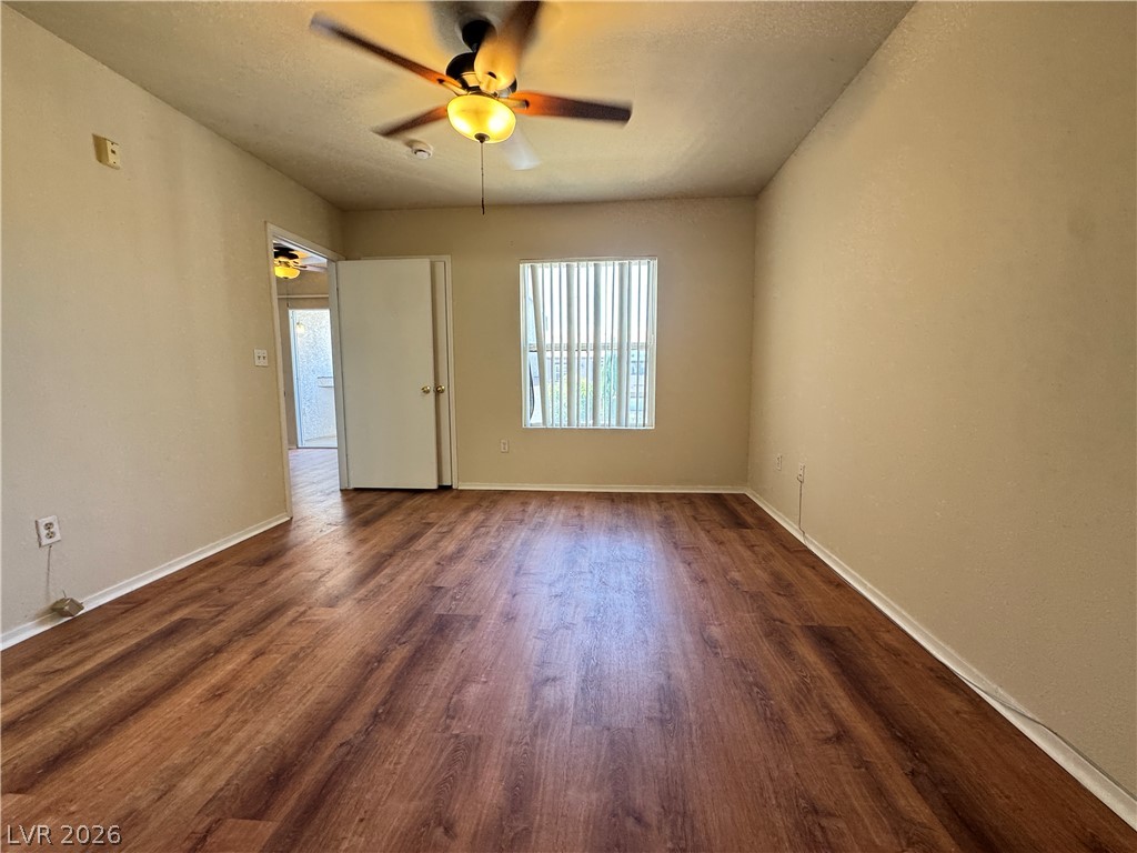 7255 West Sunset Road, Unit 2111 Las Vegas, NV 89113 - Photo 13 of 33 Well-lit living area with rich wood flooring and a refreshing ceiling fan.