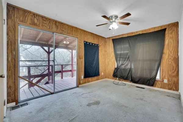 an empty room with windows and fan