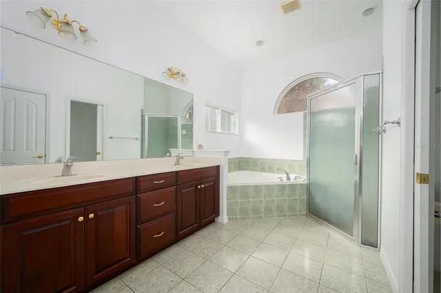 a spacious bathroom with a granite countertop sink a mirror and a bathtub