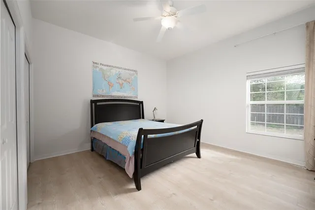 a bed sitting in a bedroom next to a window and a chandelier