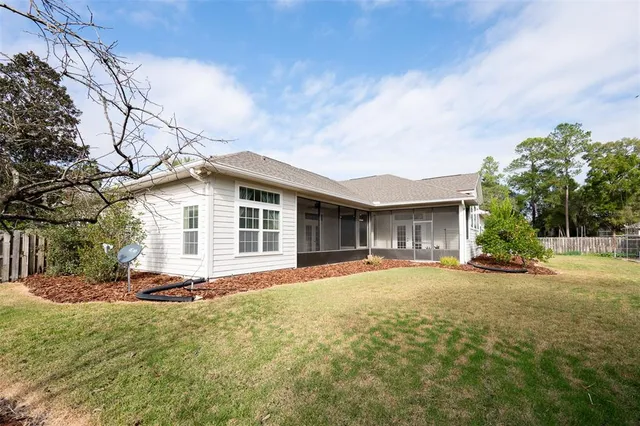 a front view of house with yard and trees in the background