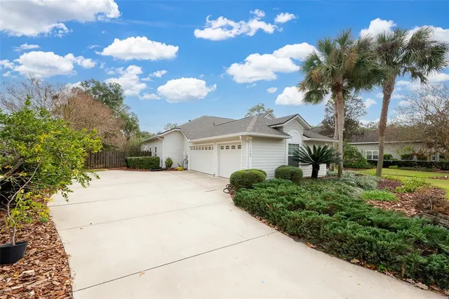 a view of a house with a big yard plants and large trees