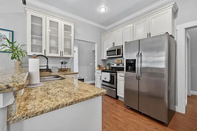 a kitchen with granite countertop a refrigerator and a sink