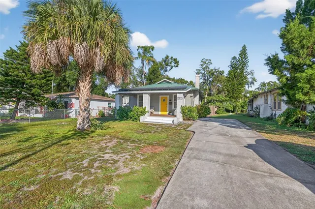 a front view of a house with a yard and trees