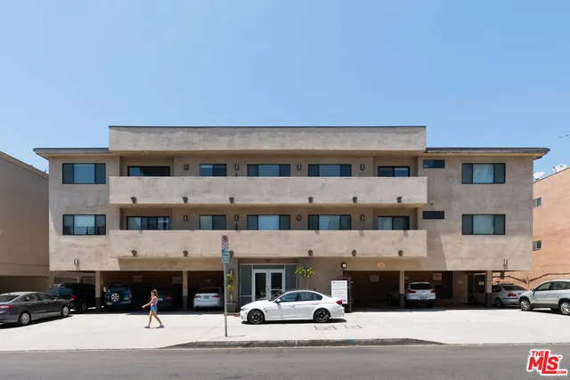 a view of a building with a barbeque and car parked