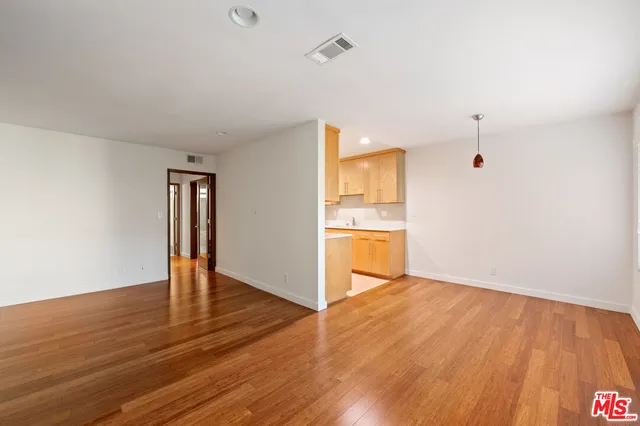 a view of a kitchen with wooden floor and a sink