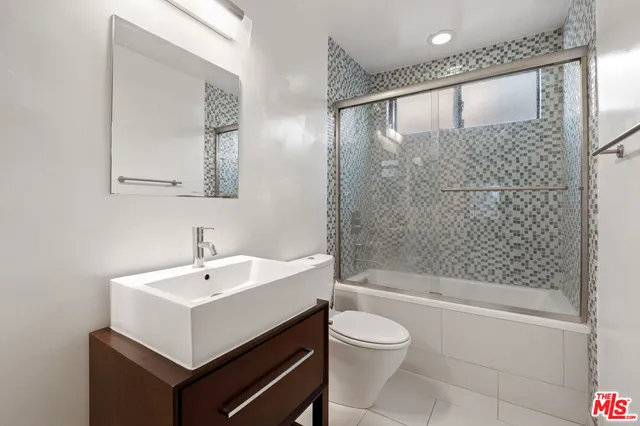 a bathroom with a sink mirror toilet and bathtub