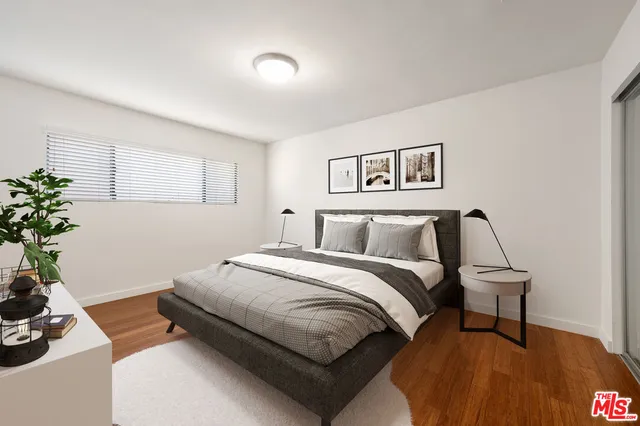 a spacious bedroom with a bed and a potted plant