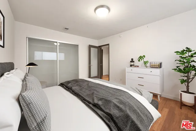 a bedroom with a bed and a potted plant