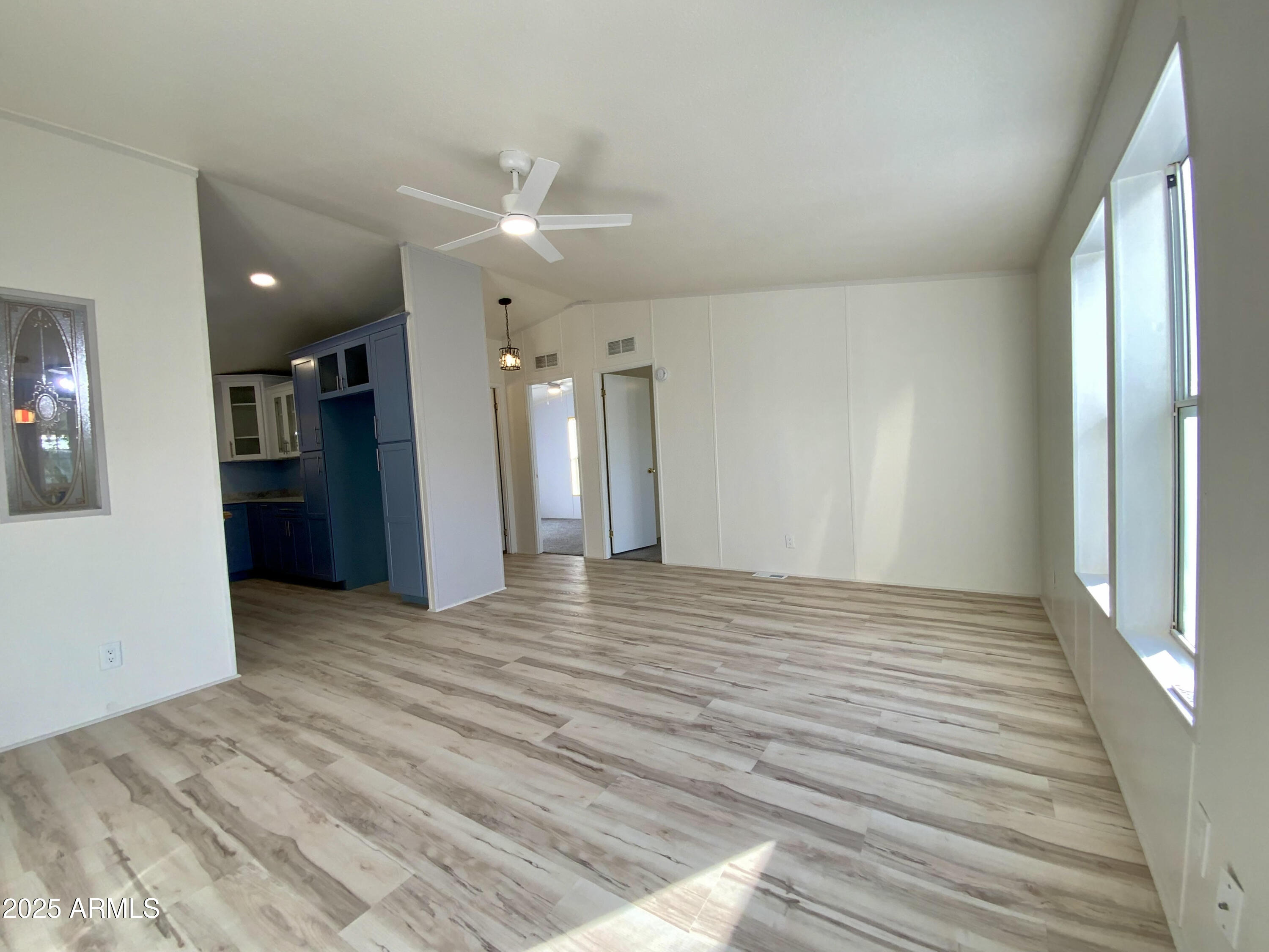 723 Finnie Flat Road, Unit 132 Camp Verde, AZ 86322 - Photo 2 of 58 a view of an empty room with wooden floor and a kitchen