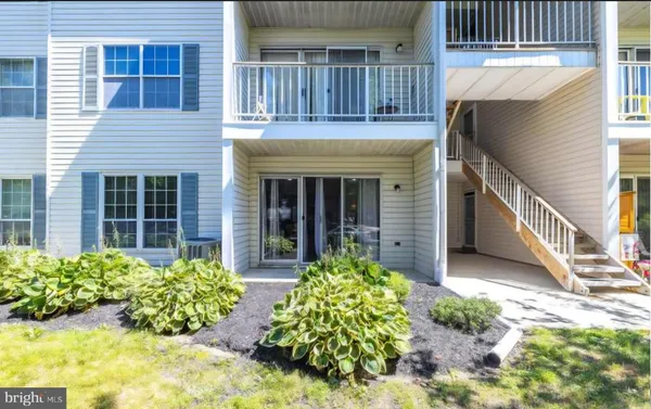 a view of a house with potted plants and a table and chairs
