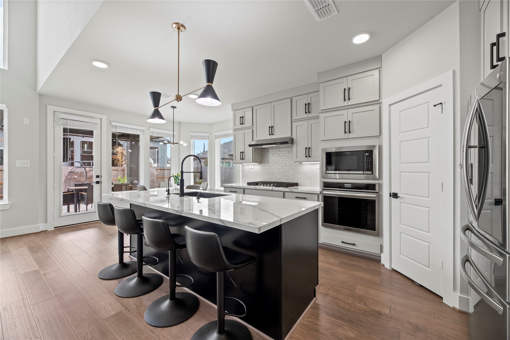 30155 GOLD FINCH Place Fulshear, TX 77441 - Photo 6 of 26 Your chef-inspired kitchen is ready to impress! This beautifully designed space features a sprawling island with breakfast bar, porcelain countertops and pendant lighting.