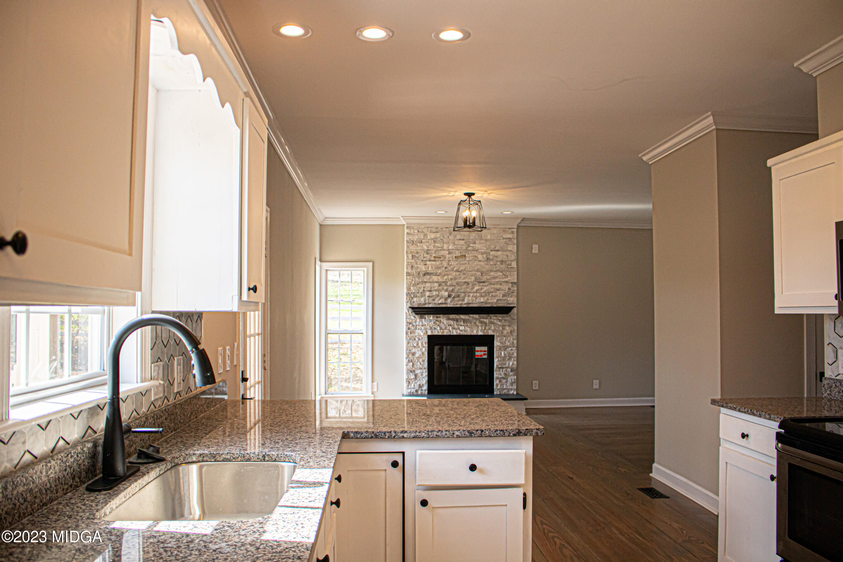 829 Lassiter Road Forsyth, GA 31029 - Photo 16 of 85 a kitchen with granite countertop a sink and a stove top oven