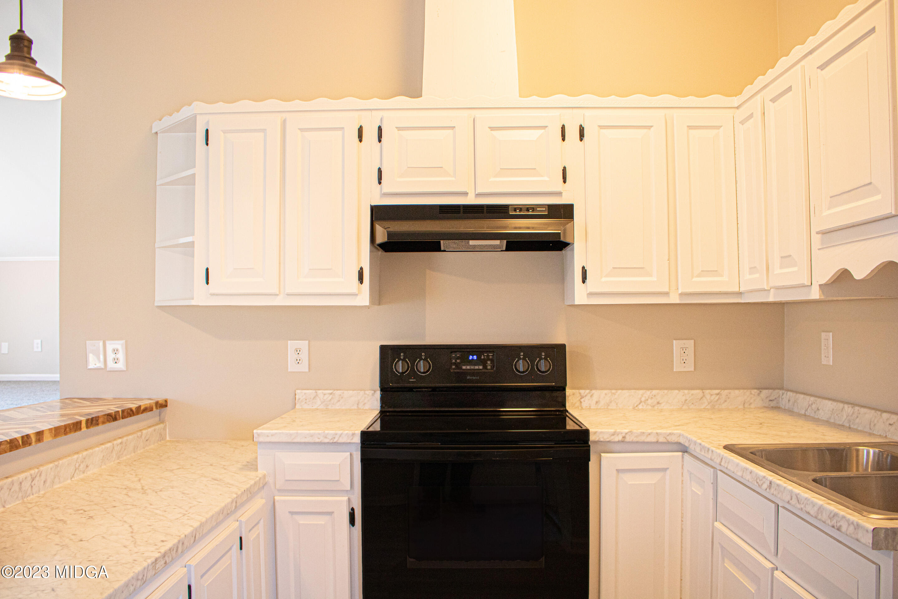 829 Lassiter Road Forsyth, GA 31029 - Photo 58 of 85 a kitchen with granite countertop a sink a stove and cabinets