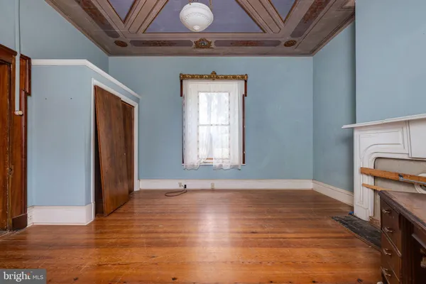 a view of an empty room with a fireplace and a window